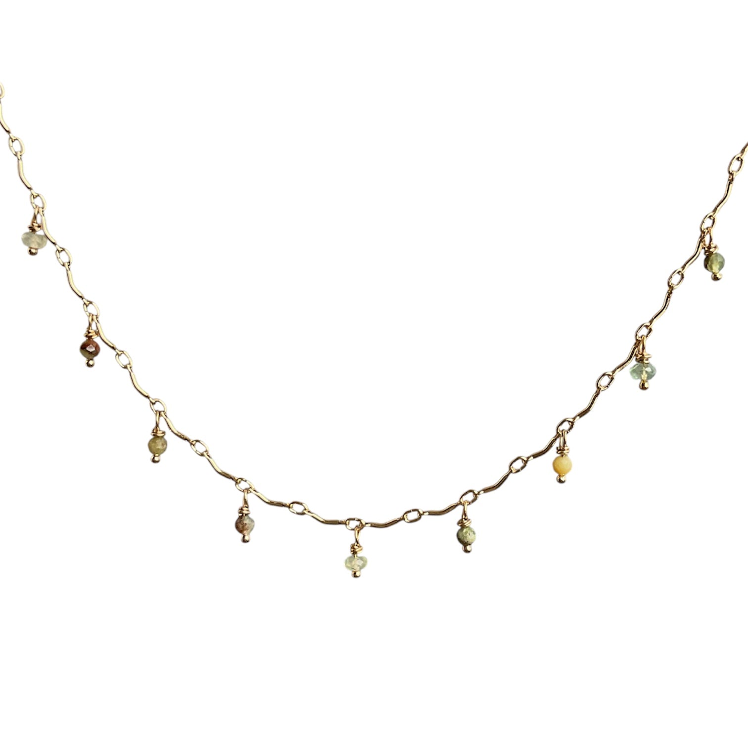 Delicate gold necklace with small beads on a white background