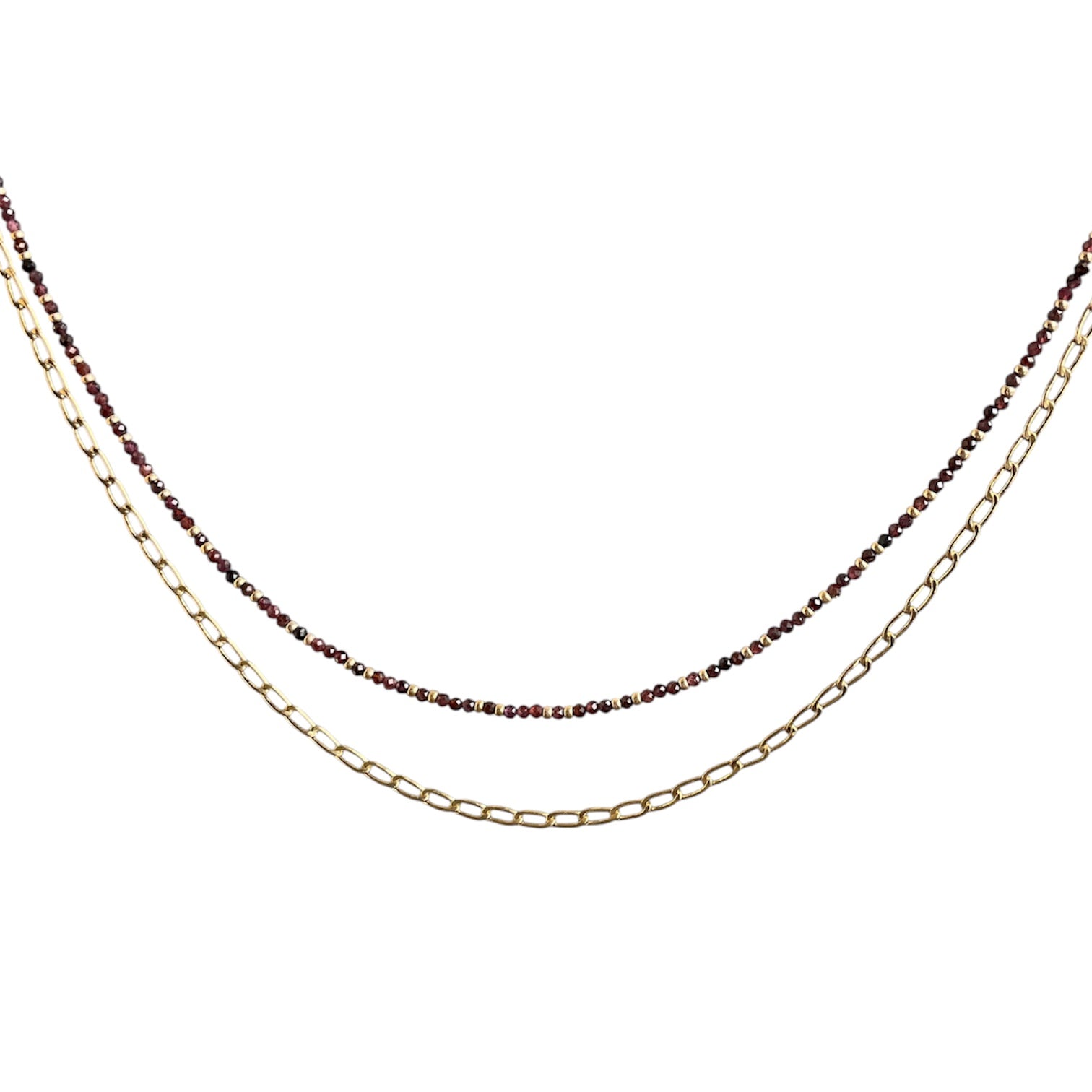 Layering necklace on a white background, one gold and one with small beads.