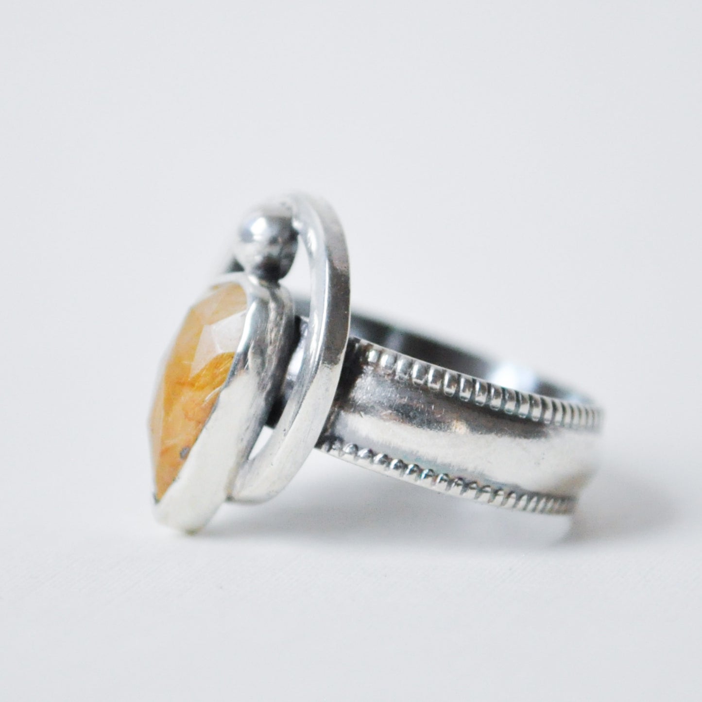 Silver ring with a stone on a white background