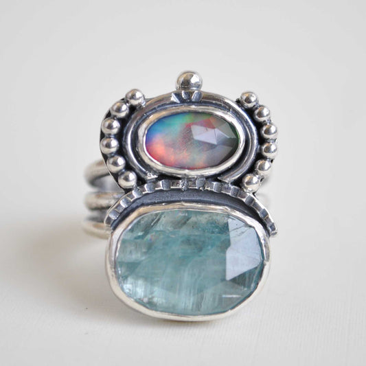Silver ring with two blue gemstones on a white background
