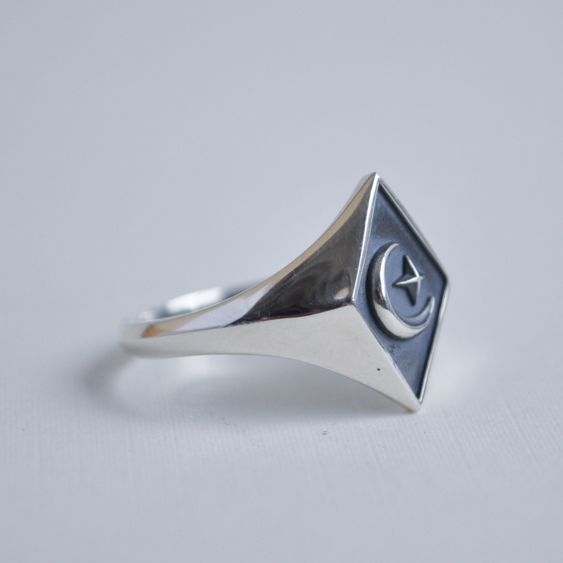 Silver ring with a geometric design on a light gray background