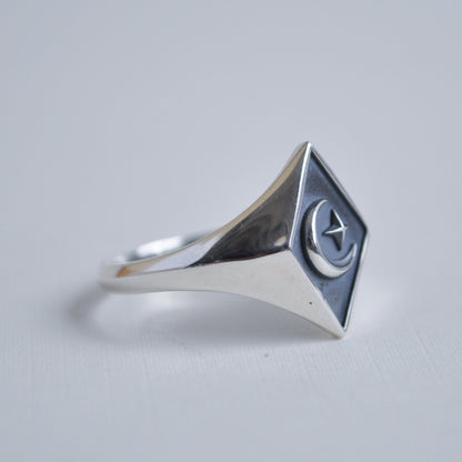 Silver ring with a geometric design on a light gray background