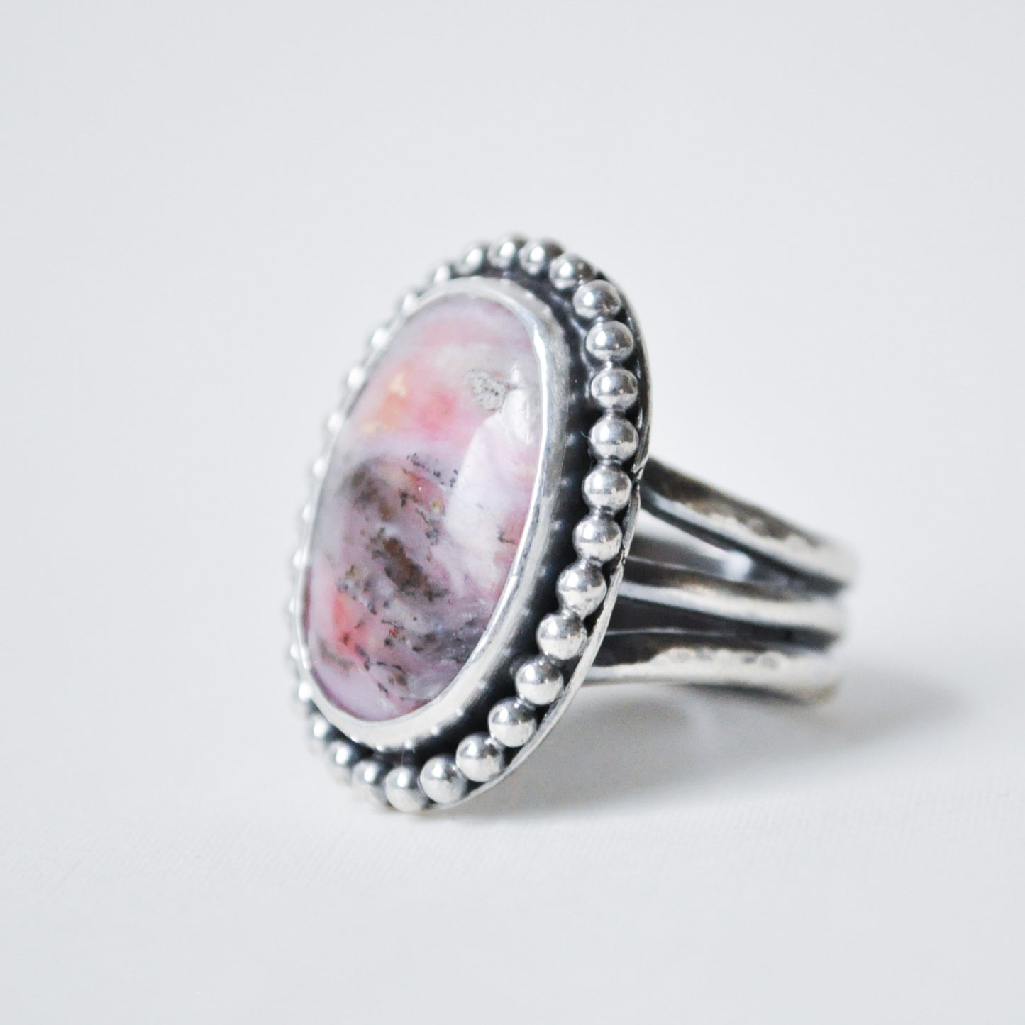 Silver ring with a pink stone on a white background