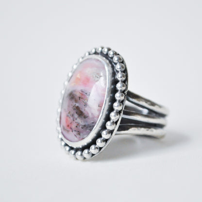 Silver ring with a pink stone on a white background