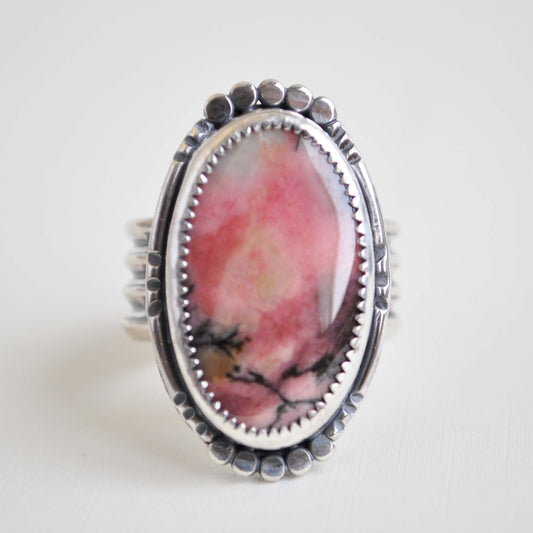 Ring with a pink stone and silver band on a white background