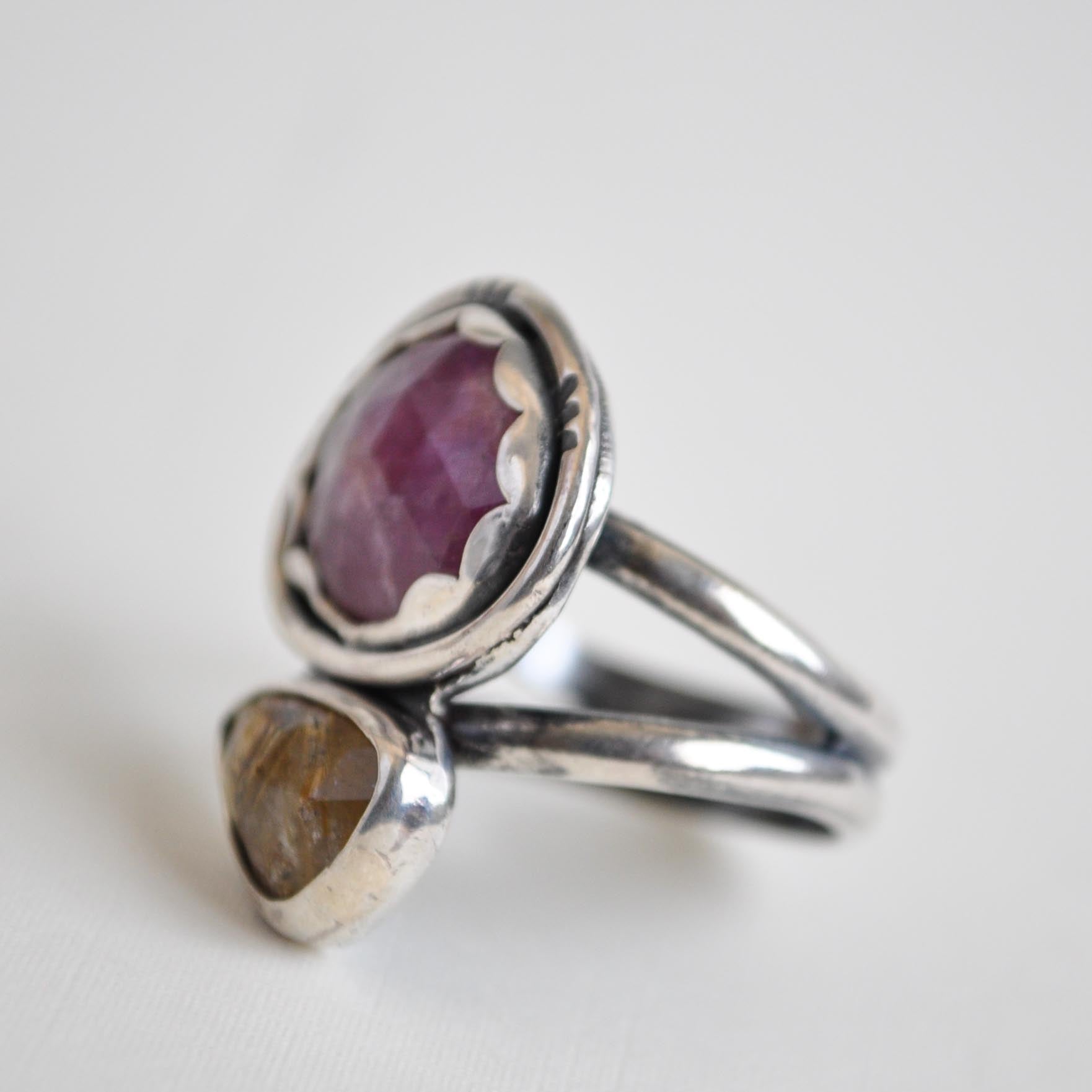 Silver ring with a purple gemstone on a white background