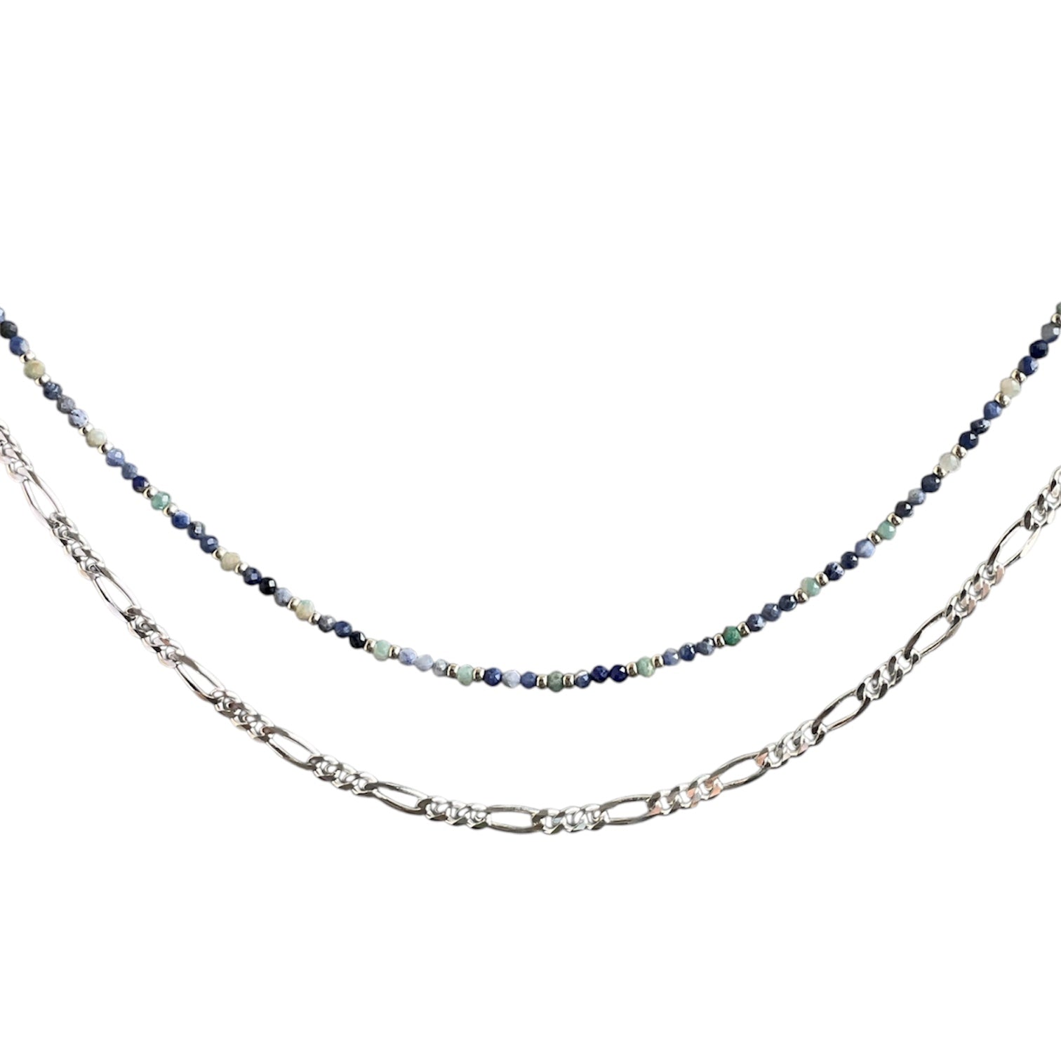 Layering necklace on a white background, one with a blue beaded chain and the other with a figaro chain.