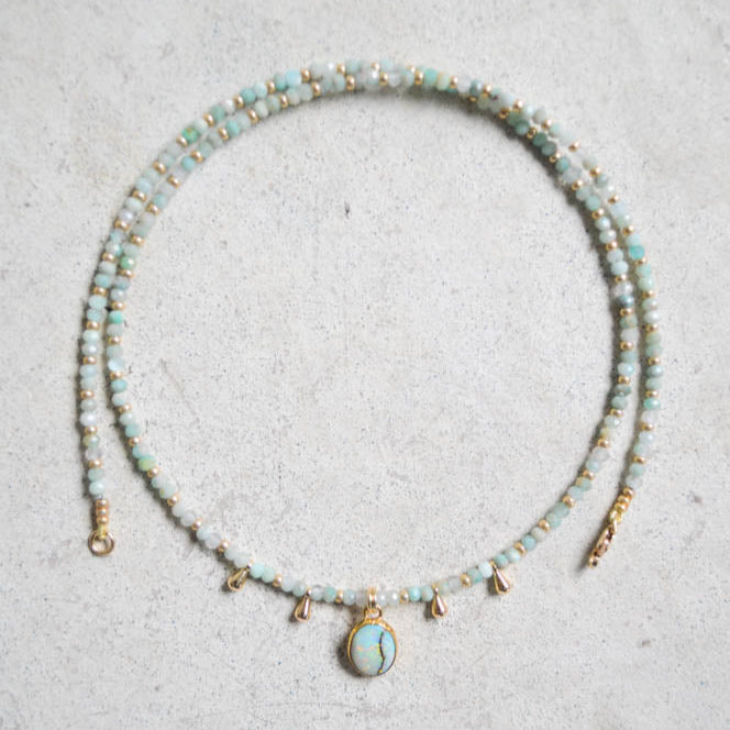 Beaded larimar and aquamarine necklace with a centered sterling opal pendant on a light gray surface