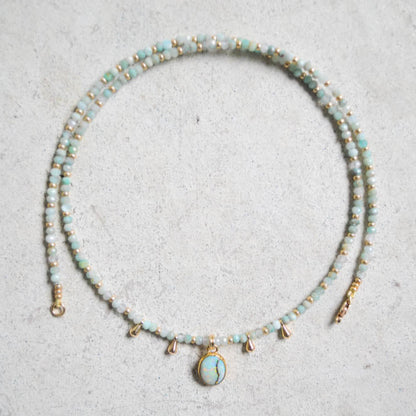 Beaded larimar and aquamarine necklace with a centered sterling opal pendant on a light gray surface