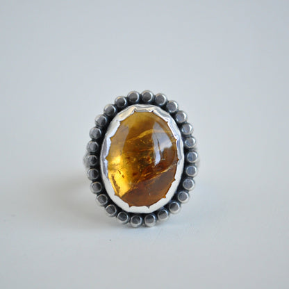 A bright and flashy citrine gemstone set in sterling silver with a beaded border and scalloped bezel setting.